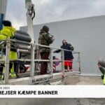 Komiker hejser kæmpe banner