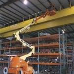 Bomlift JLG E400 AJPN på arbejde i lagerhal